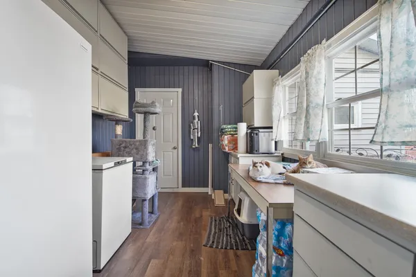 a kitchen with a sink appliances cabinets and a large window