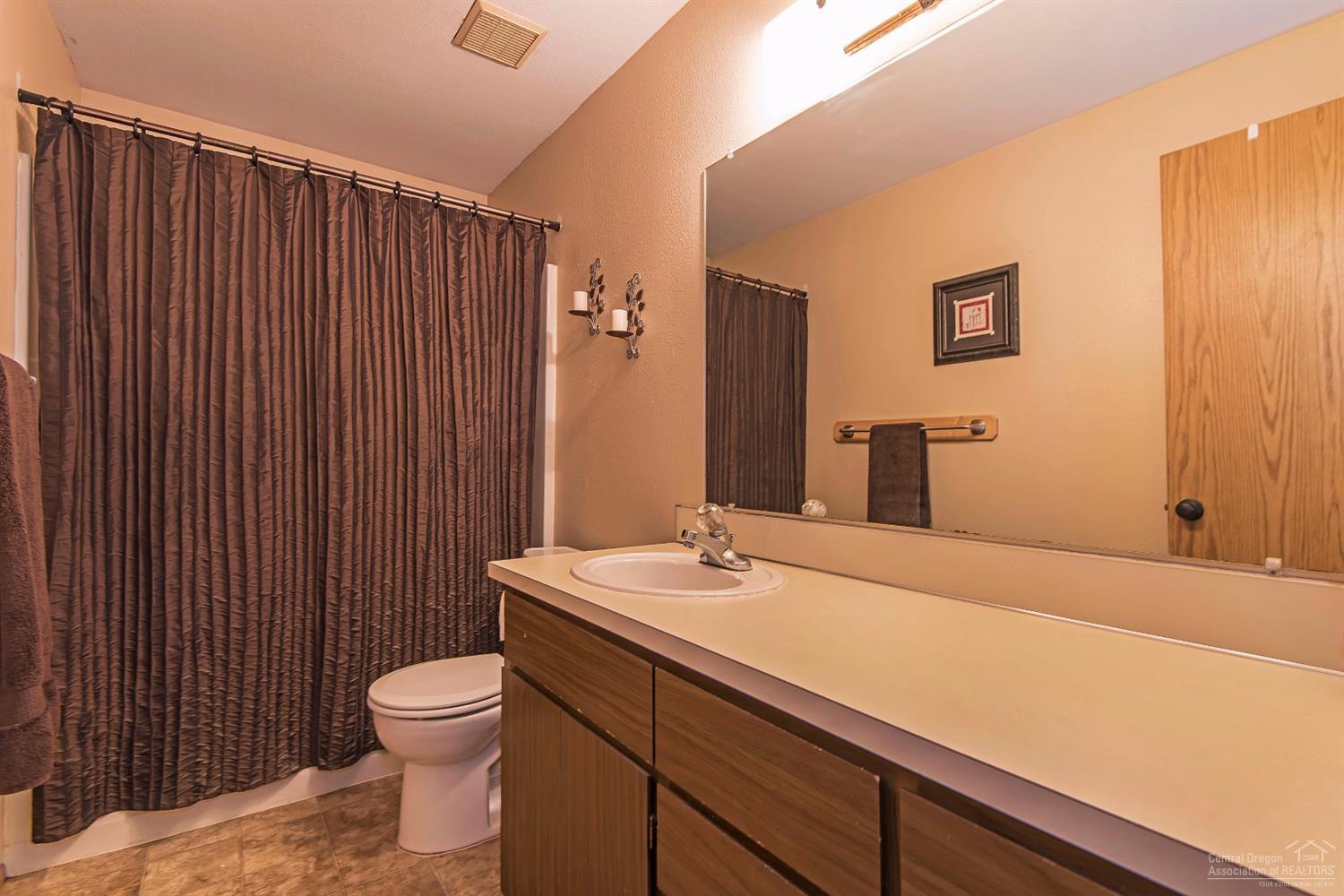63635 Boyd Acres Road Bend, OR 97701 - Photo 14 of 25 a bathroom with a sink a toilet and mirror