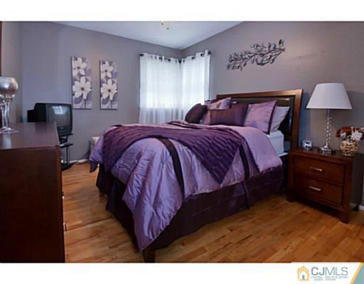 29 Orchard Road Middlesex, NJ 08846 - Photo 8 of 25 a spacious bedroom with a bed and a lamp on dresser