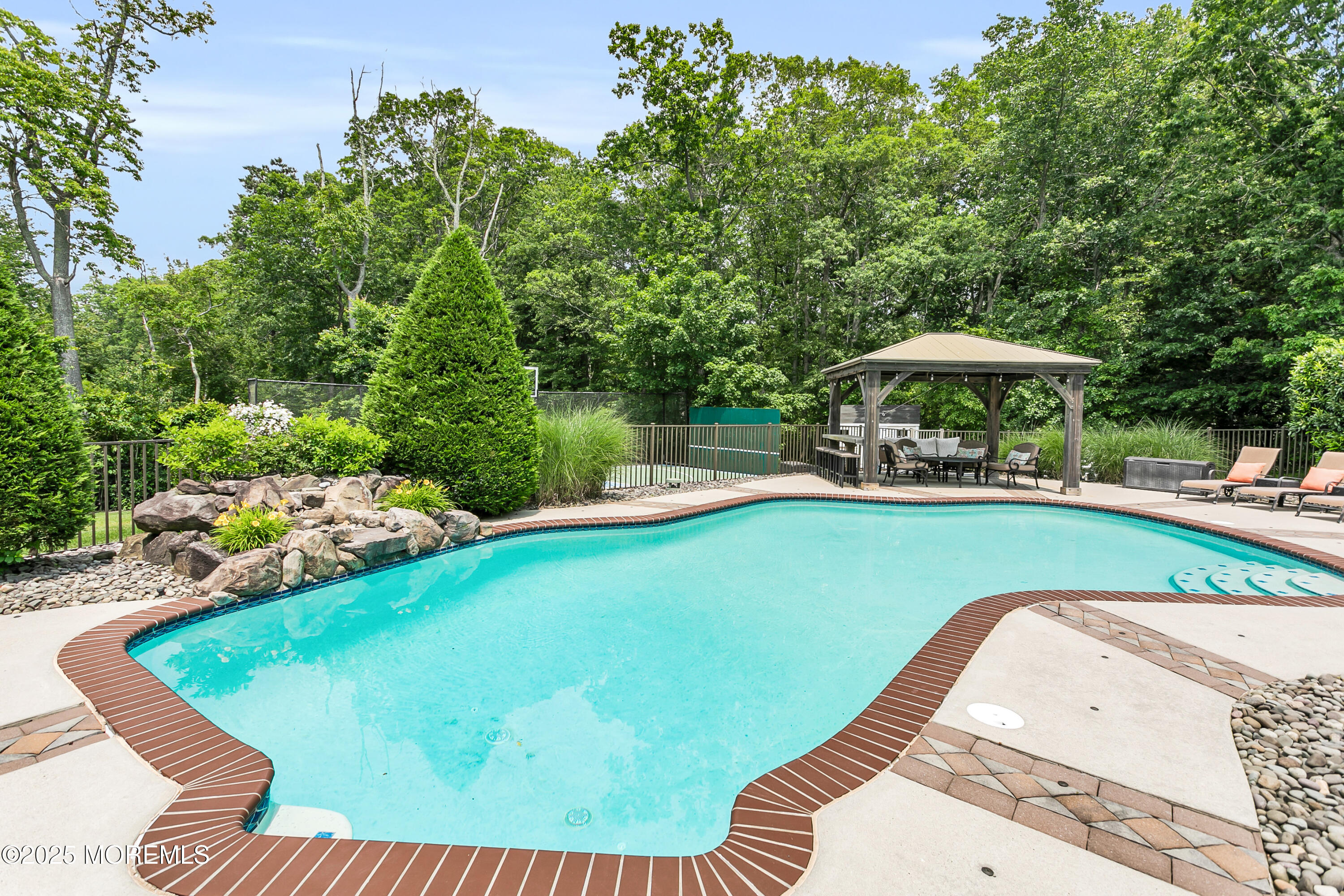 529 Woodview Road Toms River, NJ 08755 - Photo 63 of 85 a view of a swimming pool with lawn chairs under an umbrella
