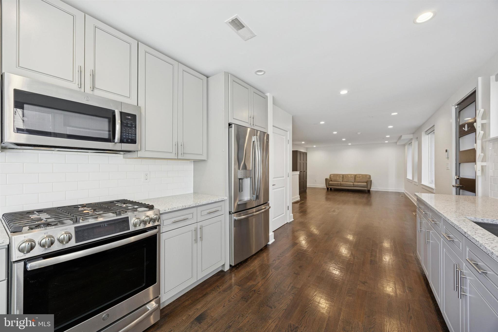 1022 South 2nd Street, Unit 7 Philadelphia, PA 19147 - Photo 8 of 28 a kitchen with stainless steel appliances a stove a microwave and a refrigerator