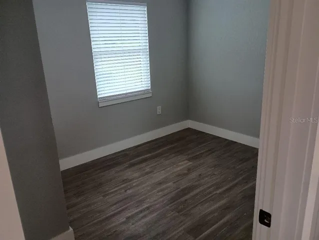 a view of a room that has wooden floor and a window
