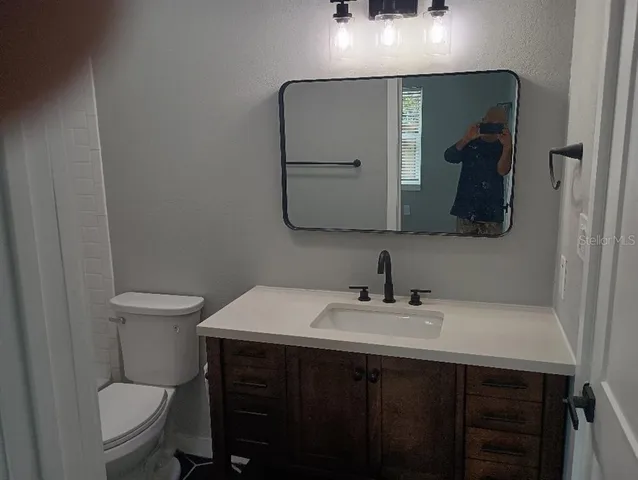 a bathroom with a sink vanity and toilet