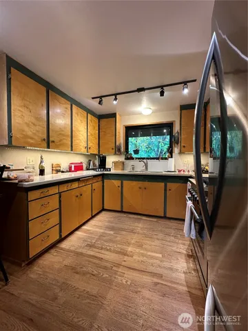 a kitchen with stainless steel appliances kitchen island granite countertop a stove sink and cabinets