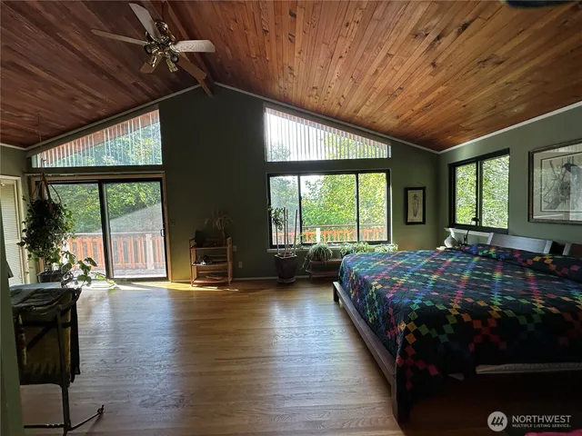 a bedroom with furniture large window and wooden floor