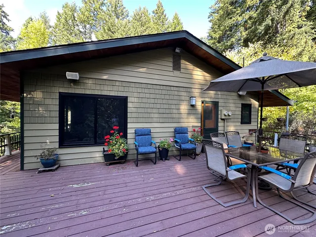 a view of a deck with table and chairs under an umbrella with wooden floor