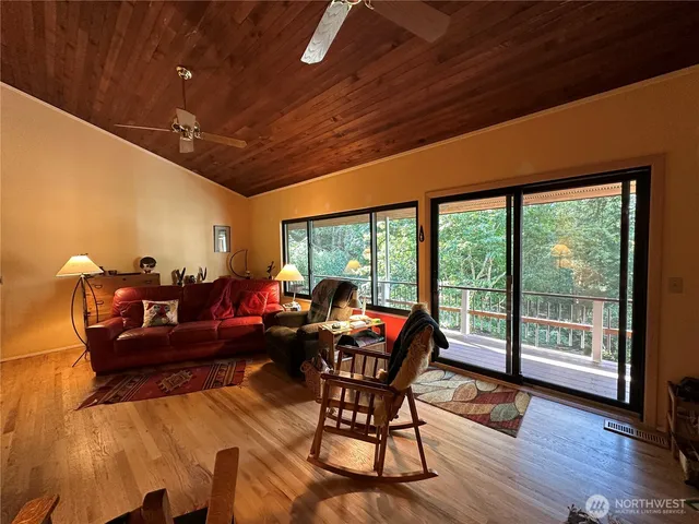 a living room with furniture a wooden floor and next to a window