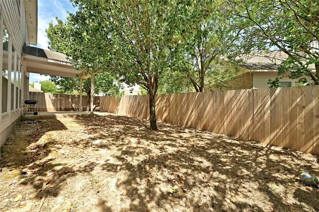 a view of a yard with wooden fence