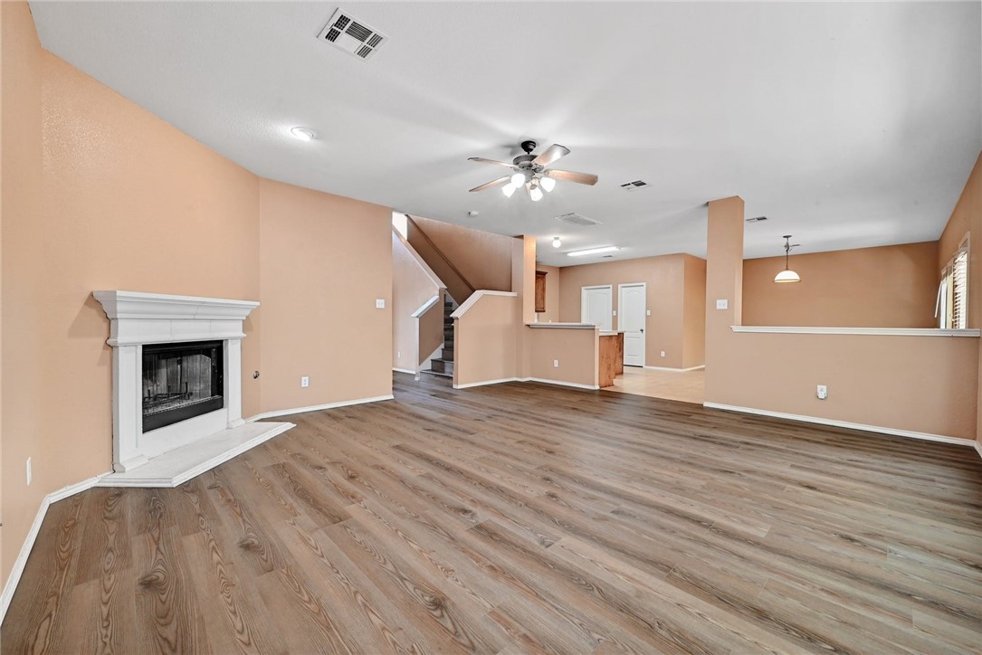 2049 Rachel Lane Round Rock, TX 78664 - Photo 4 of 36 an empty room with a fireplace and wooden floor