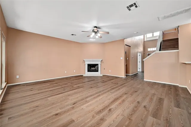 a view of a livingroom with wooden floor and a ceiling fan