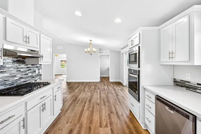 a kitchen with granite countertop a sink stove and refrigerator