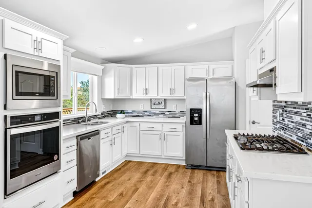a kitchen with white cabinets and stainless steel appliances