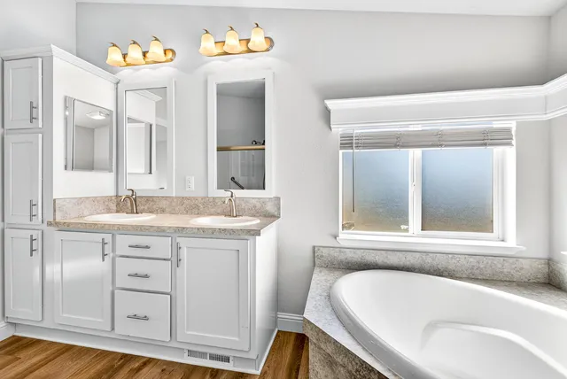 a bathroom with a granite countertop sink double vanity and a mirror