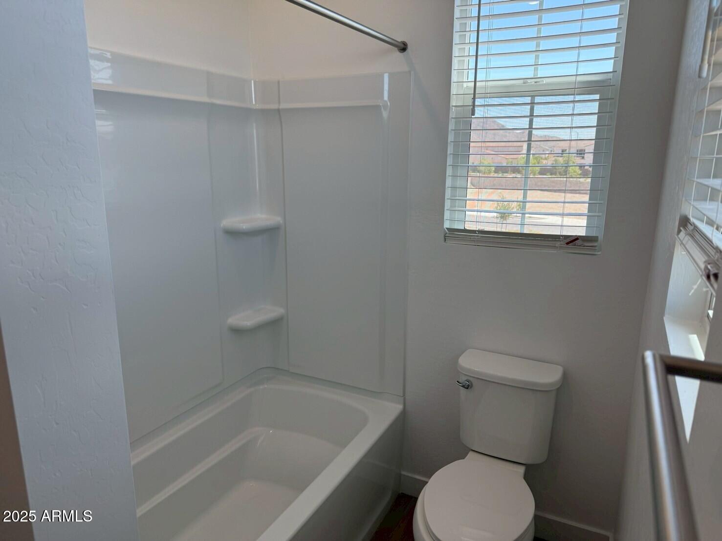 2443 West Rowel Road Phoenix, AZ 85085 - Photo 12 of 19 a white toilet sitting next to a bath tub