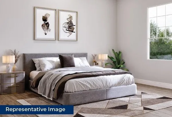 a bedroom with a bed and painting on the wall