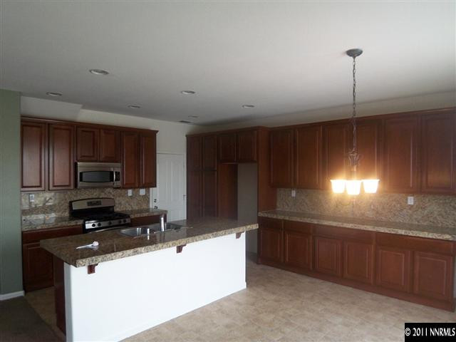 10641 Fire Poppy Circle Reno, NV 89521 - Photo 3 of 13 a kitchen with stainless steel appliances granite countertop a sink a stove and a refrigerator