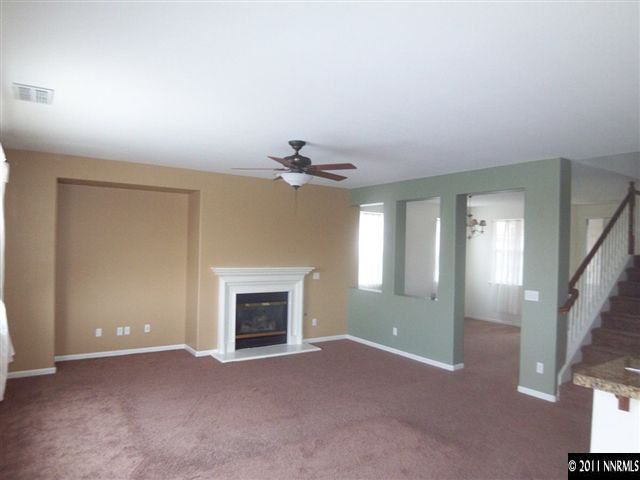 10641 Fire Poppy Circle Reno, NV 89521 - Photo 4 of 13 an empty room with windows and fireplace