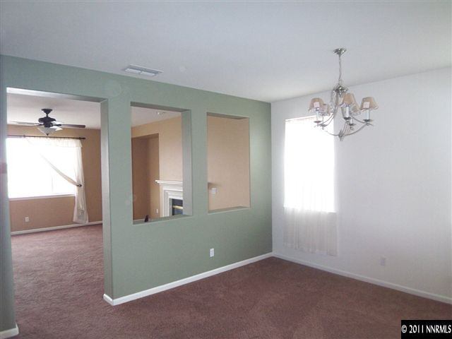 10641 Fire Poppy Circle Reno, NV 89521 - Photo 5 of 13 an empty room that has a chandelier and a chandelier