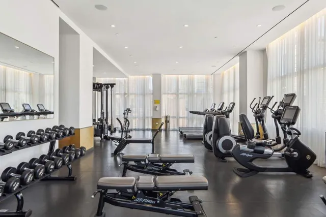 a kitchen with a stove a sink and white cabinets with wooden floor