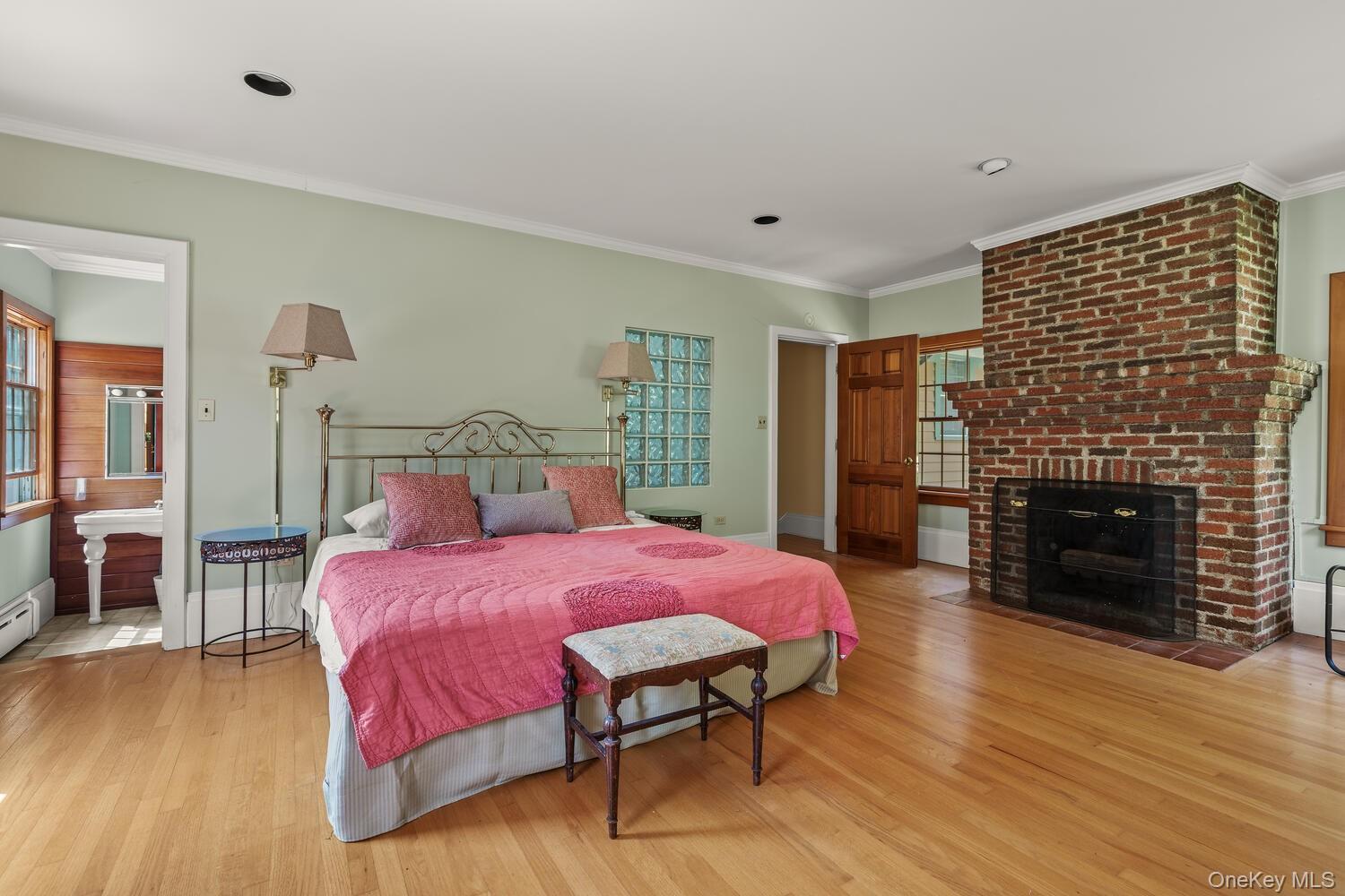 81 Glendale Road Ossining, NY 10562 - Photo 23 of 37 Bedroom with ornamental molding, light wood finished floors, a brick fireplace, and connected bathroom