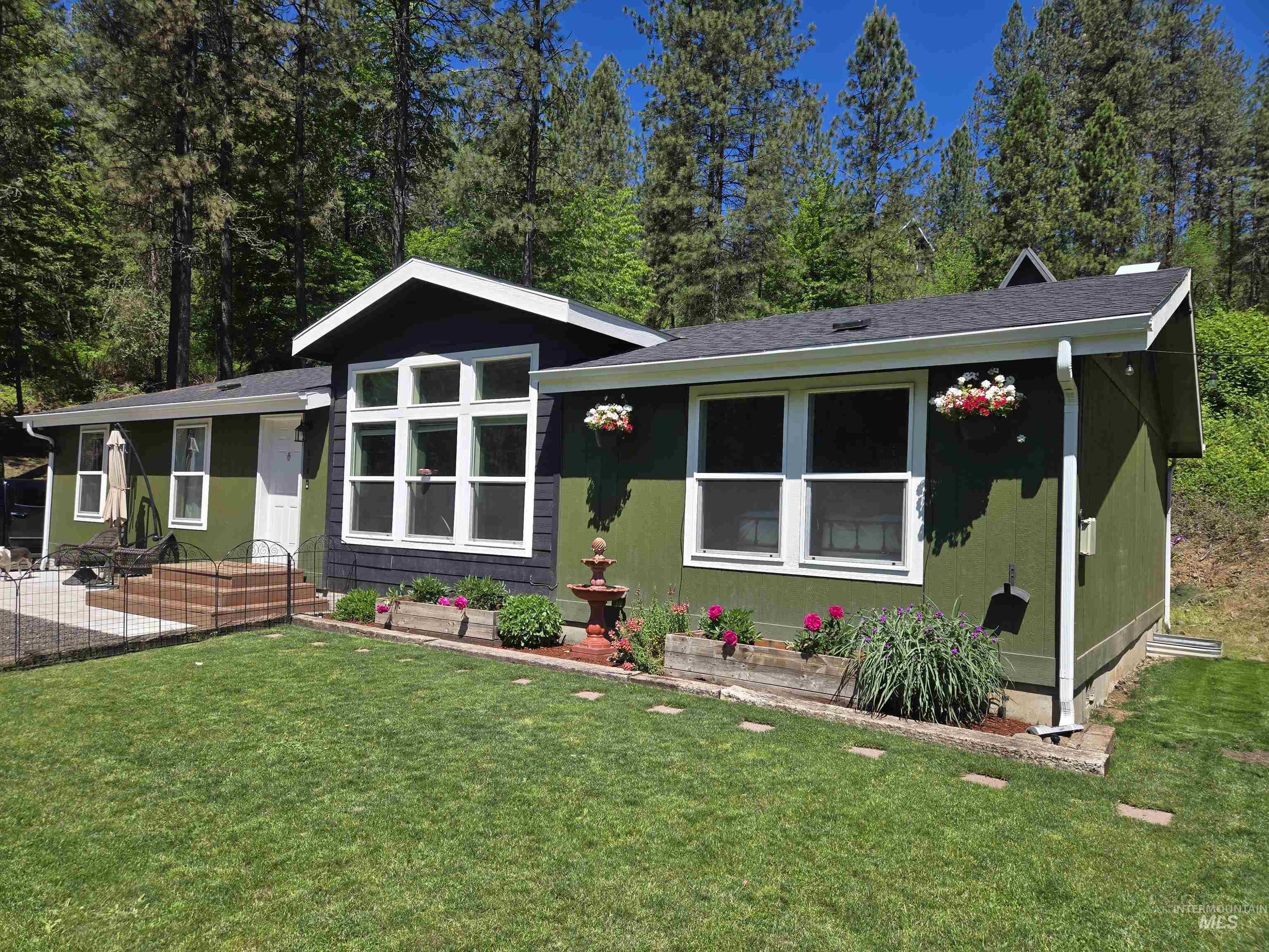 174 Konkolville Road Orofino, ID 83544 - Photo 2 of 43 Front exterior featuring green siding, a prominent multi-pane window, and a dark shingle roof