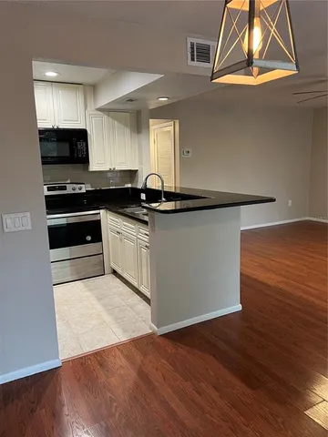 a kitchen with stainless steel appliances granite countertop a stove a sink and a microwave