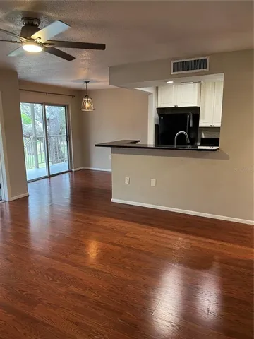 a view of kitchen and hall with wooden floor