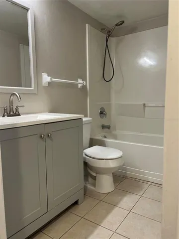 a bathroom with a toilet sink vanity granite and shower