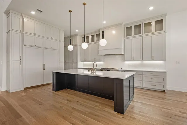 a view of a kitchen with granite countertop a stove and a wooden floor
