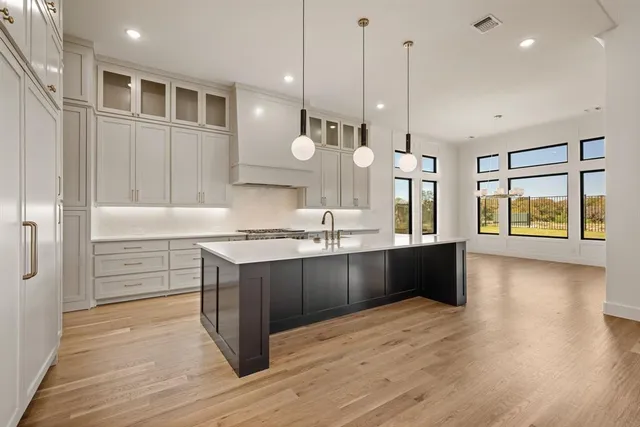 a kitchen with granite countertop a stove a sink a oven and a dining table