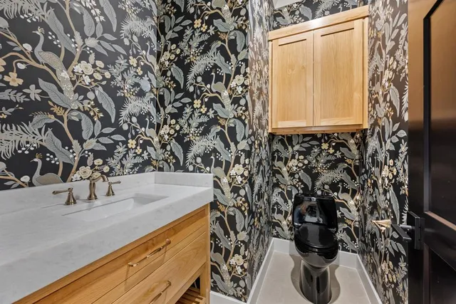 an empty room with wooden floor chandelier and windows