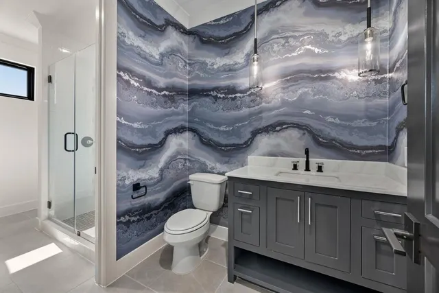 a bathroom with a granite countertop sink a toilet and shower