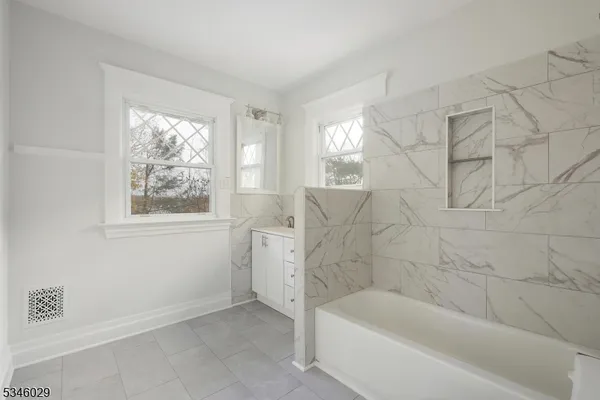 a bathroom with bathtub and window