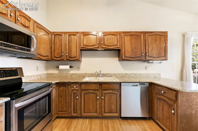 a kitchen with stainless steel appliances granite countertop a refrigerator stove and microwave