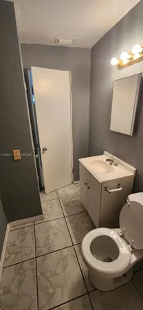 a bathroom with a toilet a sink and mirror