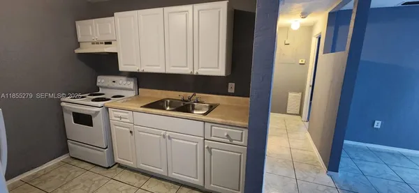a kitchen with white cabinets and white appliances