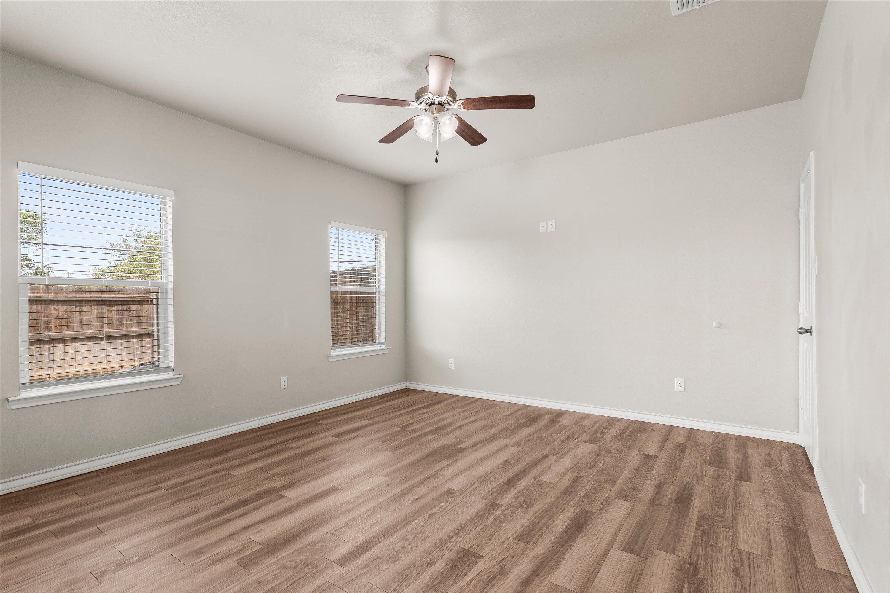 6040 24th Street, Unit 10 Lubbock, TX 79407 - Photo 11 of 29 wooden floor in an empty room with a window