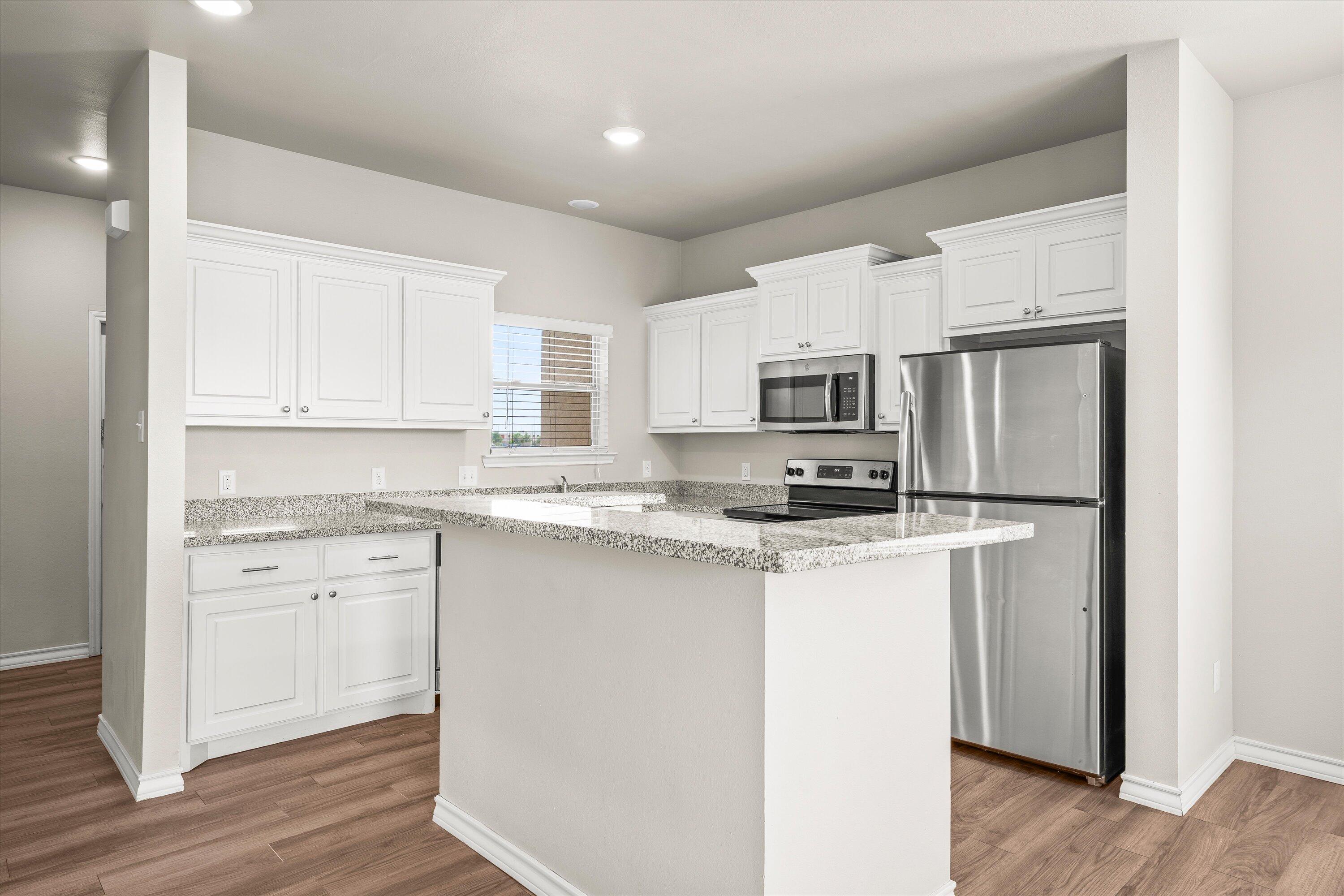 6040 24th Street, Unit 10 Lubbock, TX 79407 - Photo 12 of 29 a kitchen with stainless steel appliances granite countertop a stove top oven a refrigerator a sink and dishwasher with wooden floor
