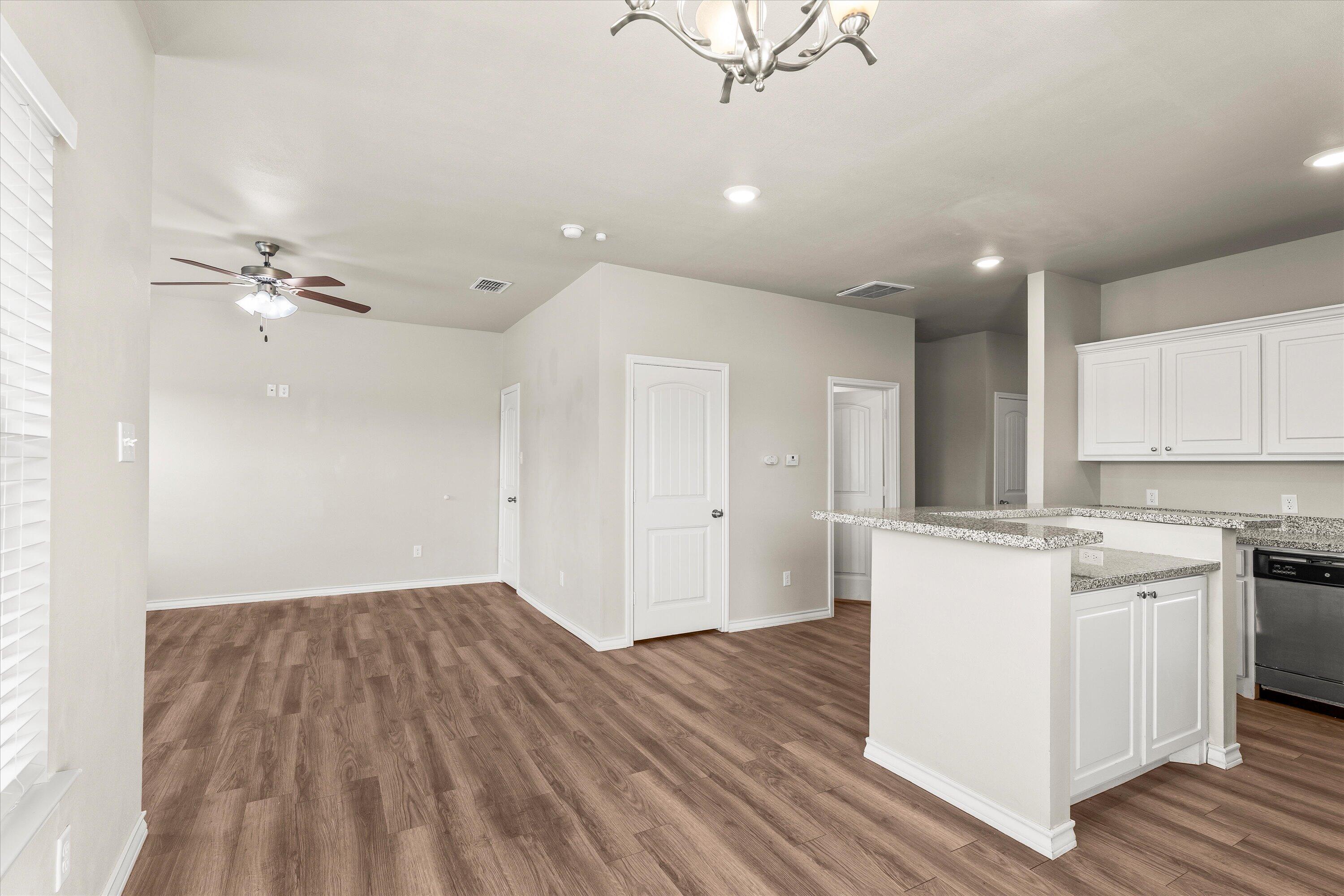 6040 24th Street, Unit 10 Lubbock, TX 79407 - Photo 13 of 29 a kitchen with kitchen island white cabinets and wooden floor