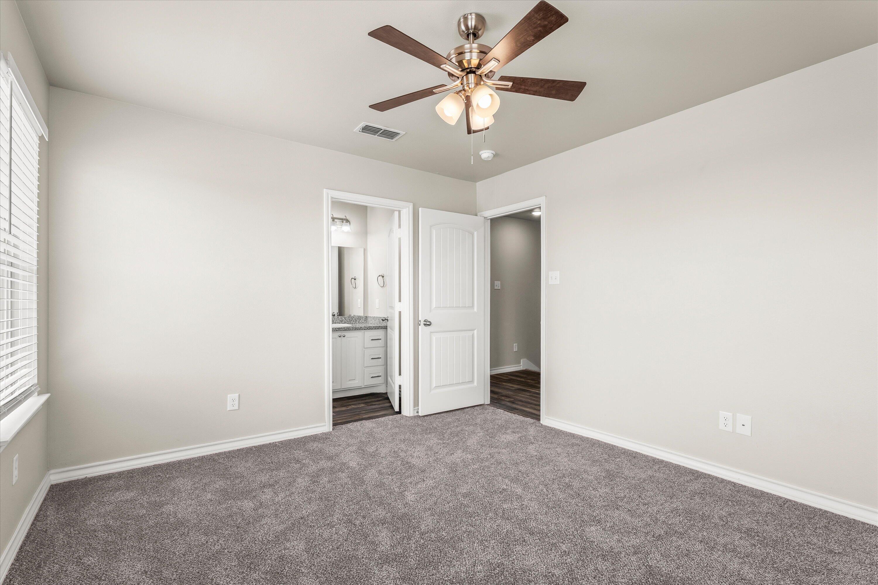 6040 24th Street, Unit 10 Lubbock, TX 79407 - Photo 21 of 29 an empty room with a ceiling fan and a window