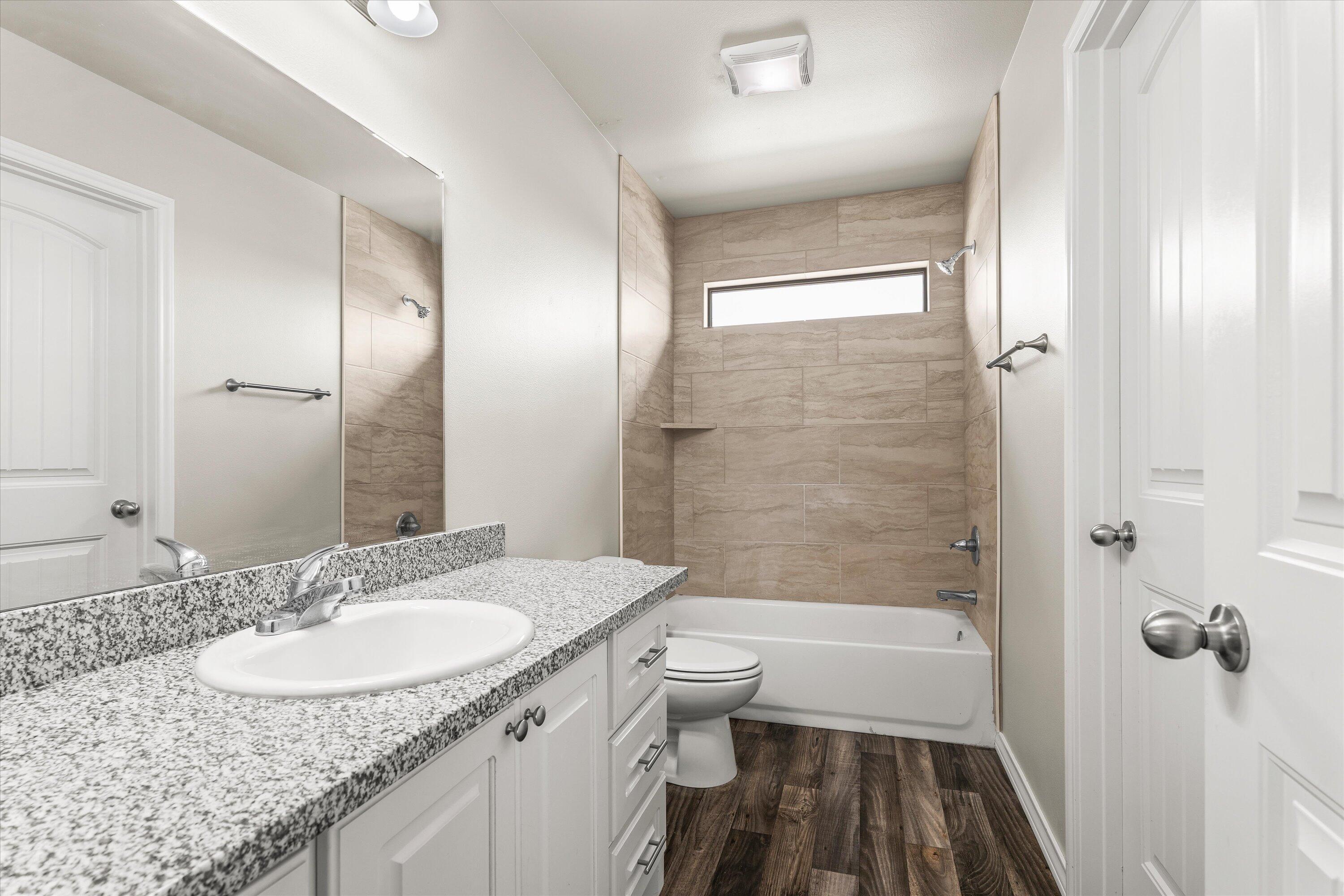 6040 24th Street, Unit 10 Lubbock, TX 79407 - Photo 25 of 29 a bathroom with a granite countertop sink toilet and shower glass cabinet