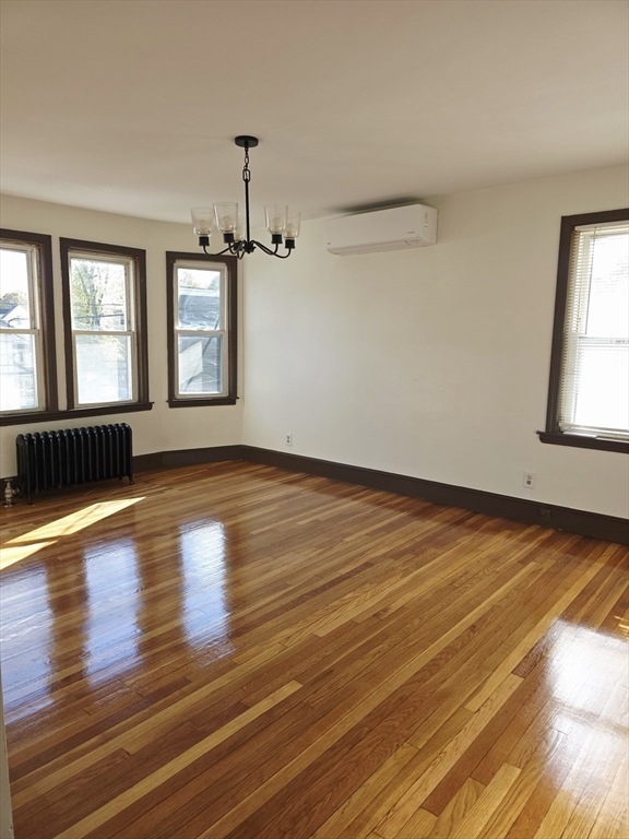 63 Evans Street, Unit 2 Boston, MA 02124 - Photo 1 of 18 an empty room with wooden floor and windows