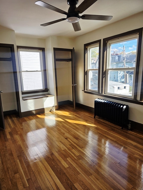 63 Evans Street, Unit 2 Boston, MA 02124 - Photo 15 of 18 a view of an empty room with window and wooden floor