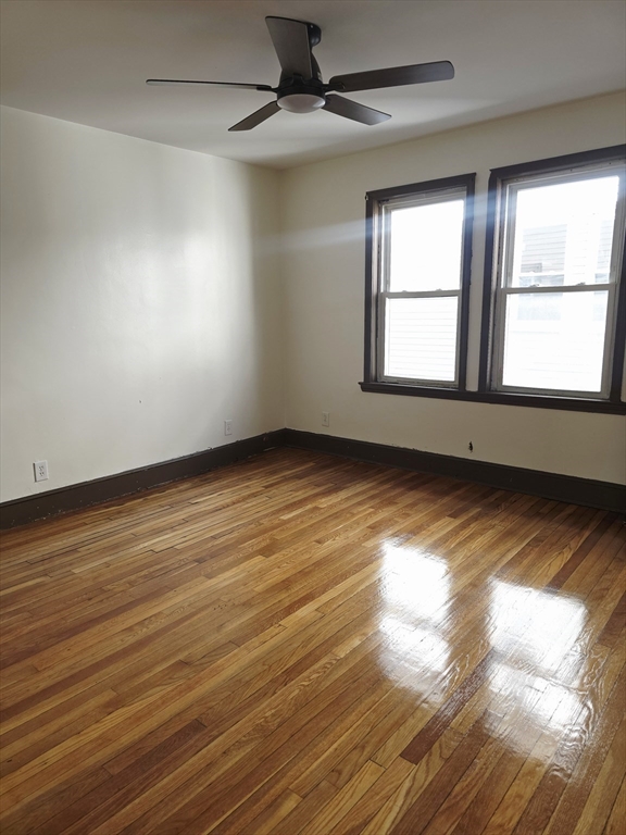63 Evans Street, Unit 2 Boston, MA 02124 - Photo 16 of 18 an empty room with wooden floor and windows