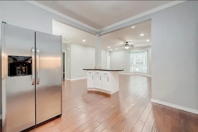 a view of a kitchen with refrigerator and wooden floor