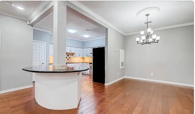 a kitchen with stainless steel appliances granite countertop a sink cabinets and wooden floor