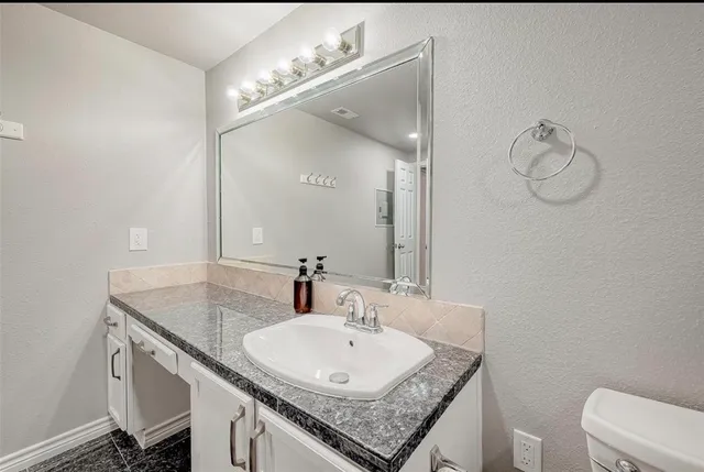 a bath room with a sink and a mirror