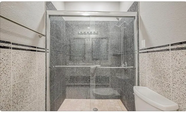 a bathroom with a shower and toilet