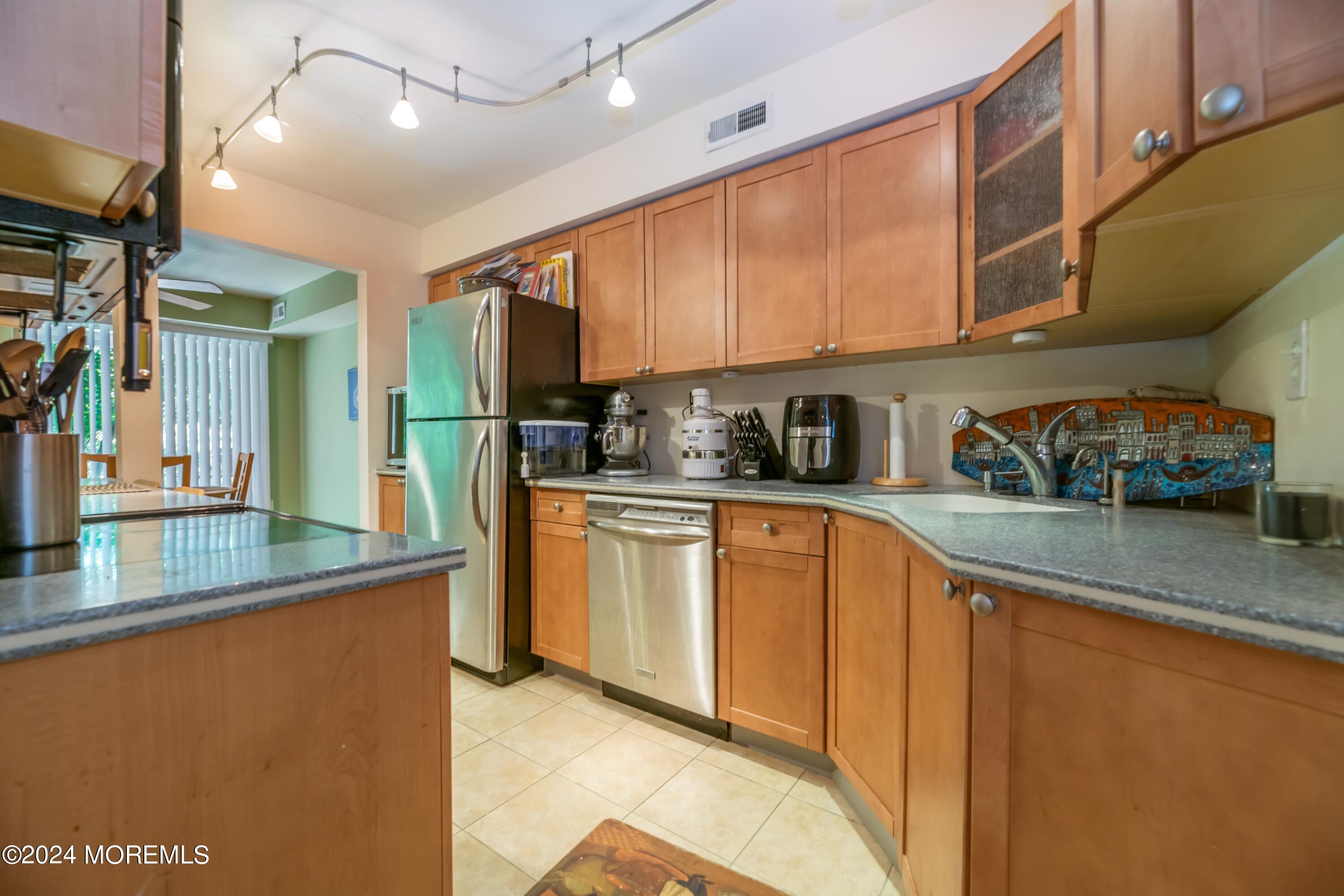 200 Portland Road, Unit D10 Highlands, NJ 07732 - Photo 11 of 16 a kitchen with stainless steel appliances granite countertop a sink a stove and a refrigerator