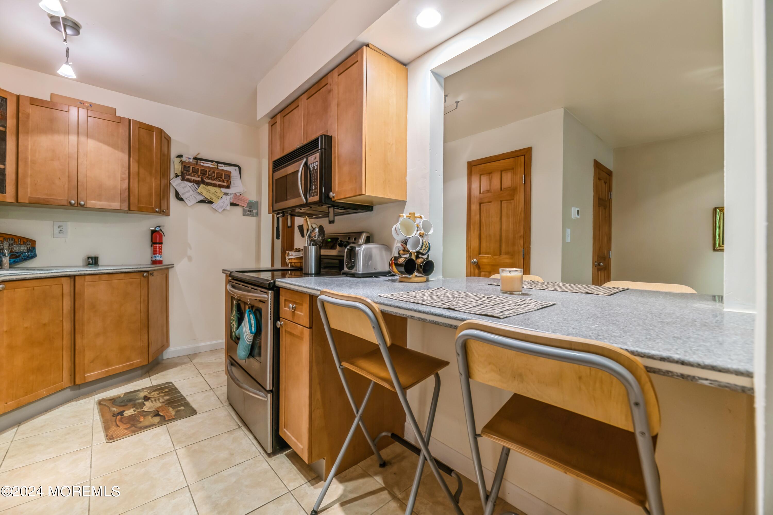 200 Portland Road, Unit D10 Highlands, NJ 07732 - Photo 14 of 16 a kitchen with stainless steel appliances granite countertop a sink and cabinets